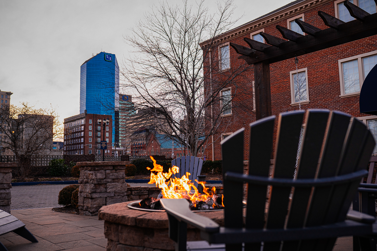 Fire pit on a downtown Lexington hotel patio, brick building and the Fifth Third tower in the background