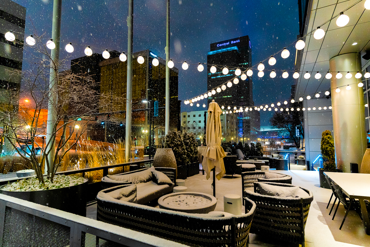 Snowy rooftop patio in downtown Lexington with string lights and the Central Bank Center tower in the skyline